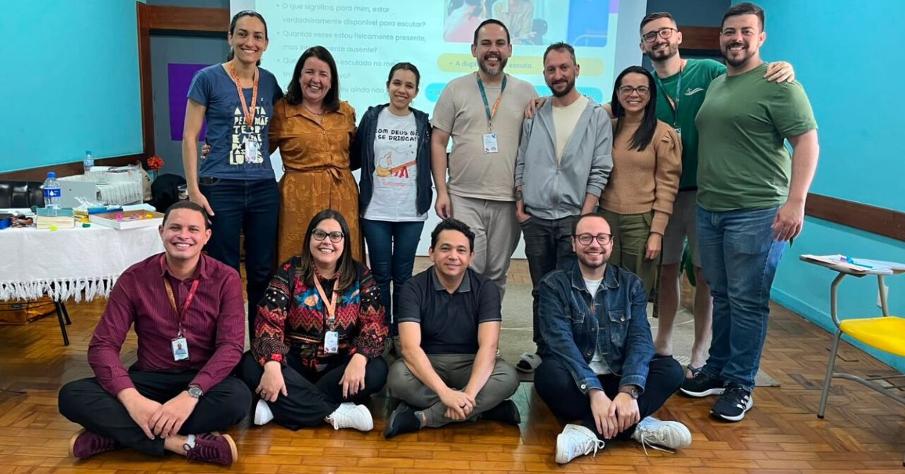 Texto alternativo: Grupo de colaboradores do Centro MAGIS Anchietanum reunido durante formação do Projeto de Vida. Treze pessoas posam para a foto em uma sala onde foram realizadas atividades de formação, reflexão e partilha.